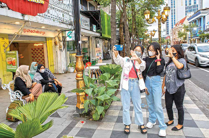 NGABUBURIT: Sejumlah warga Kota Surabaya dan sekitarnya memanfaatkan waktu luang menunggu buka puasa dengan berfoto di kawasan Jalan Tunjungan, Surabaya, Senin (3/4). - Image