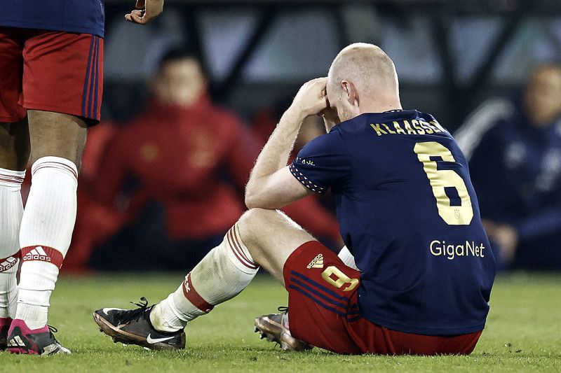 Pemain tengah Ajax Davy Klaassen duduk di lapangan saat laga semifinal Piala Belanda melawan Feyenoord. Laga dihentikan pada menit ke-63, korek api dilempar dari tribun mengenai kepala Klaassen - Image