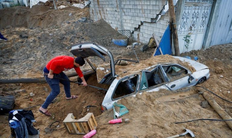 Seorang warga Palestina memeriksa mobil yang rusak setelah serangan udara Israel di Kota Gaza (7/4). - Image