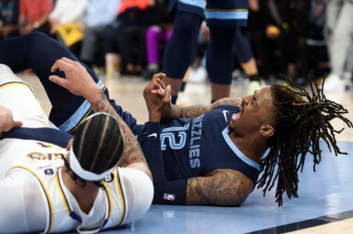 Bintang Memphis Grizzlies, Ja Morant (kanan) memegangi tangannya usai terjatuh ditabrak pemain LA Lakers. - Image