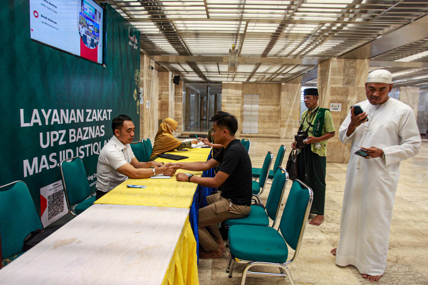 Petugas Amil Zakat melayani umat Islam yang membayar zakat fitrah di Masjid Istiqlal, Jakarta, Kamis (20/4/2023). Baznas Masjid Istiqlal membuka layanan zakat fitrah hingga malam takbiran dengan besaran 3,5 liter atau 2,7 kilogram beras atau uang sebesar - Image