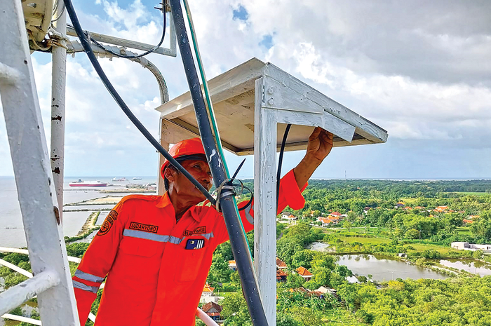 BANTU LALU LINTAS KAPAL: Sudaryono sedan memperbaiki perlatan di menara suar. Sudaryono termasuk karyawan yang berdedikasi terhadap pekerjaannya. - Image