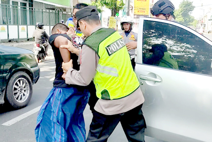 RINGKUS: Petugas Polisi mengamankan pria tak dikenal yang sempat meresahkan masyarakat di perempatan Jember, Kudus kemarin. - Image