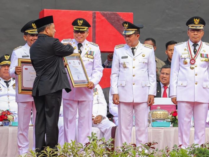 Mendagri Tito Karnavian saat menyerahkan penghargaan untuk daerah dengan kinerja terbaik pada peringatan Hari Otda ke-27 di Kota Makassar, Sabtu (29/4). - Image