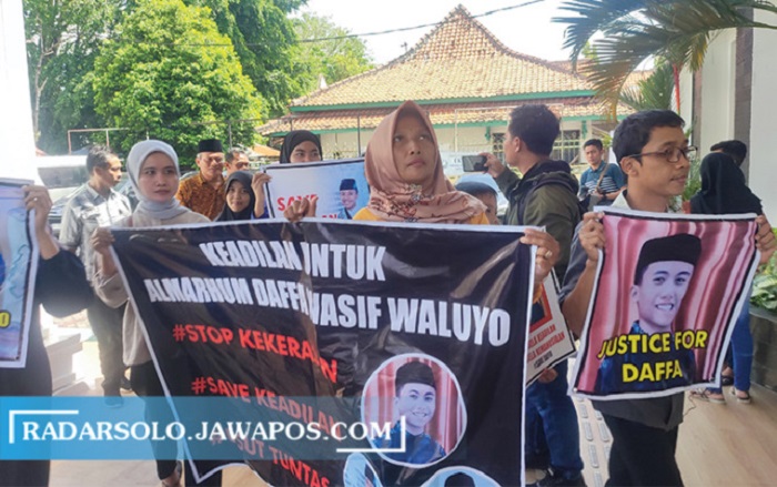 Keluarga Daffa Washif Waluyo saat membentangkan spanduk di PN Sragen. - Image