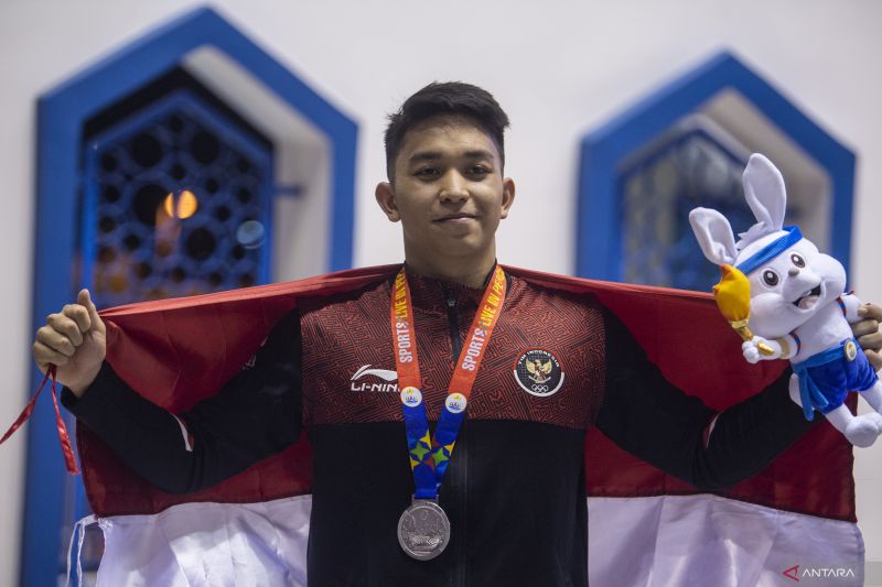Perenang Indonesia Farrel ArmandioTangkas menunjukan medali perak seusai penyematan medali pada nomor 100m gaya punggung putra saat SEA Games 2023. (ANTARA) - Image
