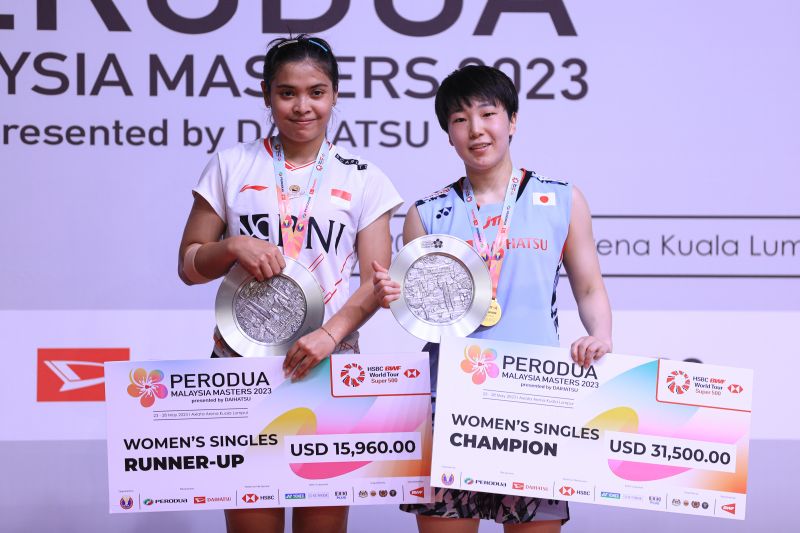 Gregoria Mariska Tunjung saat menaiki podium penyerahan hadiah Malaysia Masters 2023 bersama sang juara Akane Yamaguchi (kanan) di Kuala Lumpur, Minggu (28/5). - Image