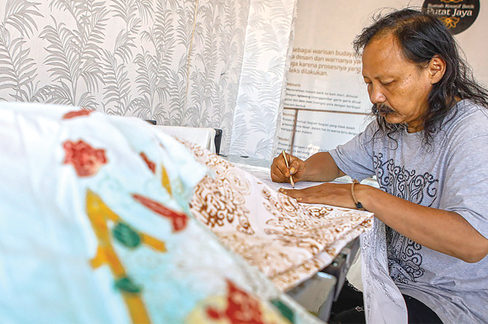 BUATAN WARGA: Mulyadi Gunawan membuat batik khas Surabaya yang dipesan beberapa instansi pemerintah beberapa waktu lalu. Batik jarak arum merupakan batik yang banyak dipesan. - Image
