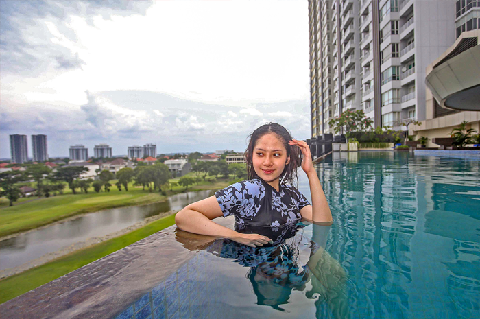 NYAMAN: Aulia Sabrina menggunakan fasilitas umum apartemen di kawasan Surabaya Barat kemarin (30/5). Fasilitas itu mendukung aktivitas dan kebutuhan penghuni. - Image