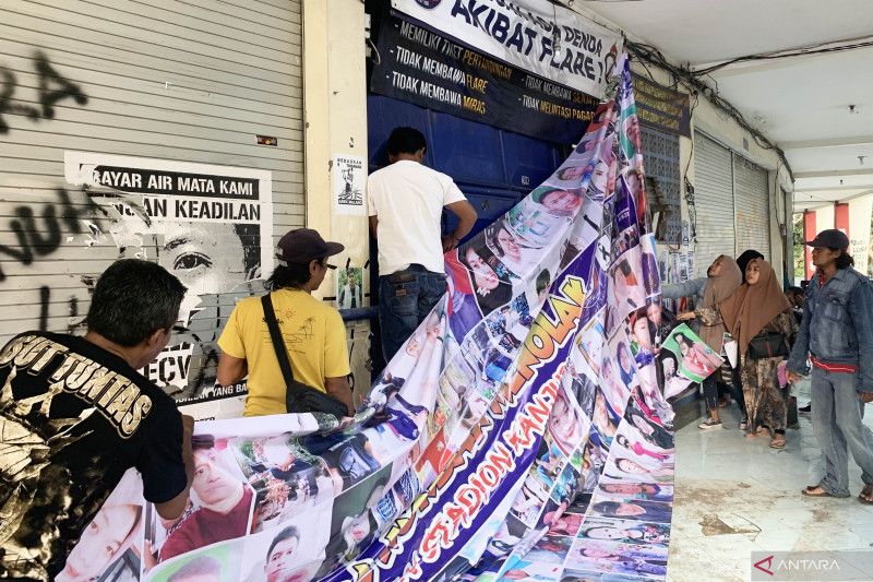 Perwakilan keluarga korban Tragedi Kanjuruhan memasang poster untuk menyampaikan penolakan terhadap pembongkaran Stadion Kanjuruhan di Kabupaten Malang, Provinsi Jawa Timur, Sabtu (3/6). - Image