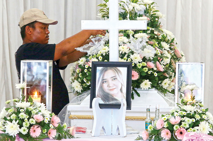 PERSEMAYAMAN TERAKHIR: Petugas menata bunga di peti jenazah korban pembunuhan Angeline Nathania di Krematorium Adi Jasa, Kamis (8/6). - Image