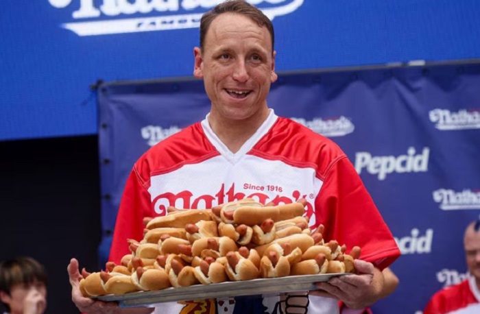 Juara Dunia Joey Chestnut saat upacara penimbangan berat badan menjelang Kontes Makan Hot Dog Internasional Fourth of July 2023. - Image