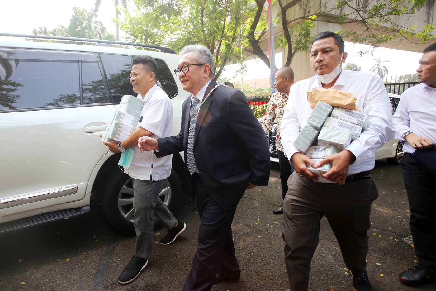 Pengacara Maqdir Ismail membawa segepok uang dolar Amerika Serikat senilai USD 1,8 juta atau setara Rp 27 miliar ke Kejaksaan Agung, Kamis (13/7). - Image