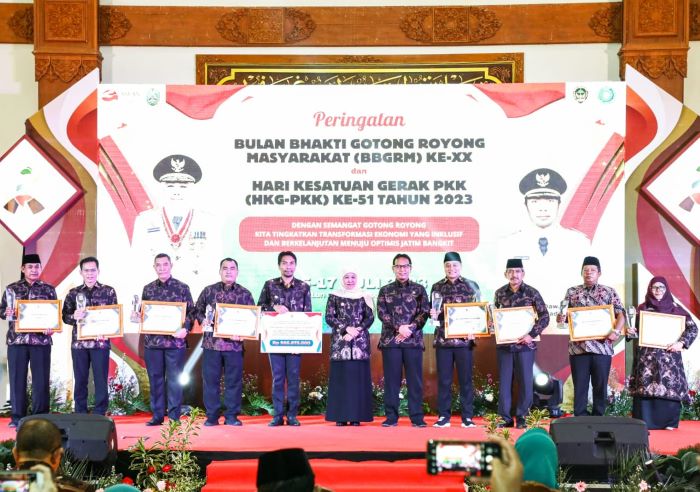 Gubernur Jawa Timur Khofifah Indar Parawansa menyerahkan penghargaan kepada pelaksana gotong royong terbaik Provinsi Jatim dalam rangkaian peringatan BBGRM XX & HKG PKK. - Image