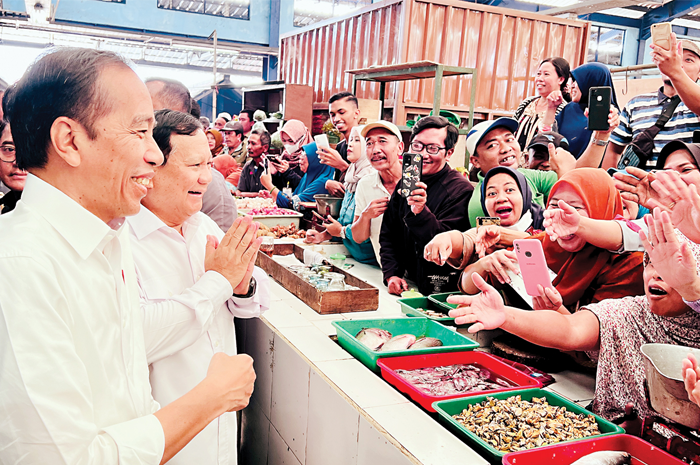 MENYAPA MASYARAKAT: Presiden Jokowi bersama Menhan Prabowo menyapa para pedagang di Pasar Bululawang kemarin (24/7). Kegiatan itu digelar di sela-sela kunjungan ke PT Pindad. - Image
