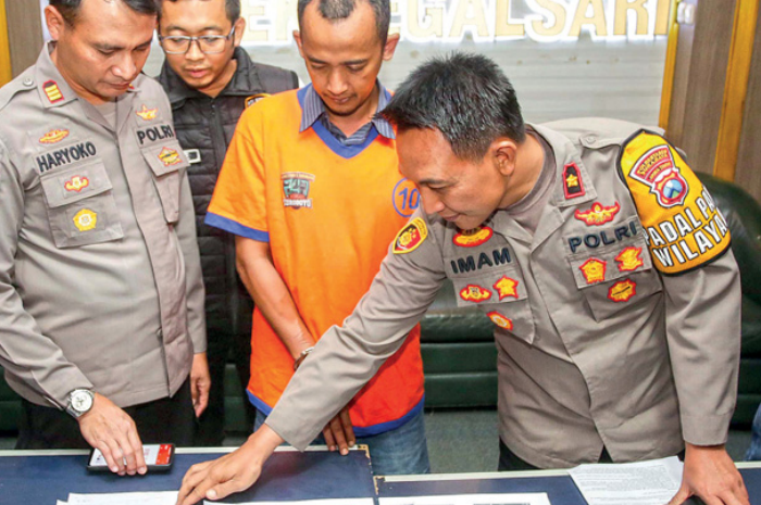 CALO PPDB: Tersangka kasus penipuan PPDB Diki Afrian digelandang polisi saat ungkap kasus di Mapolsek Tegalsari, Selasa (25/7). - Image