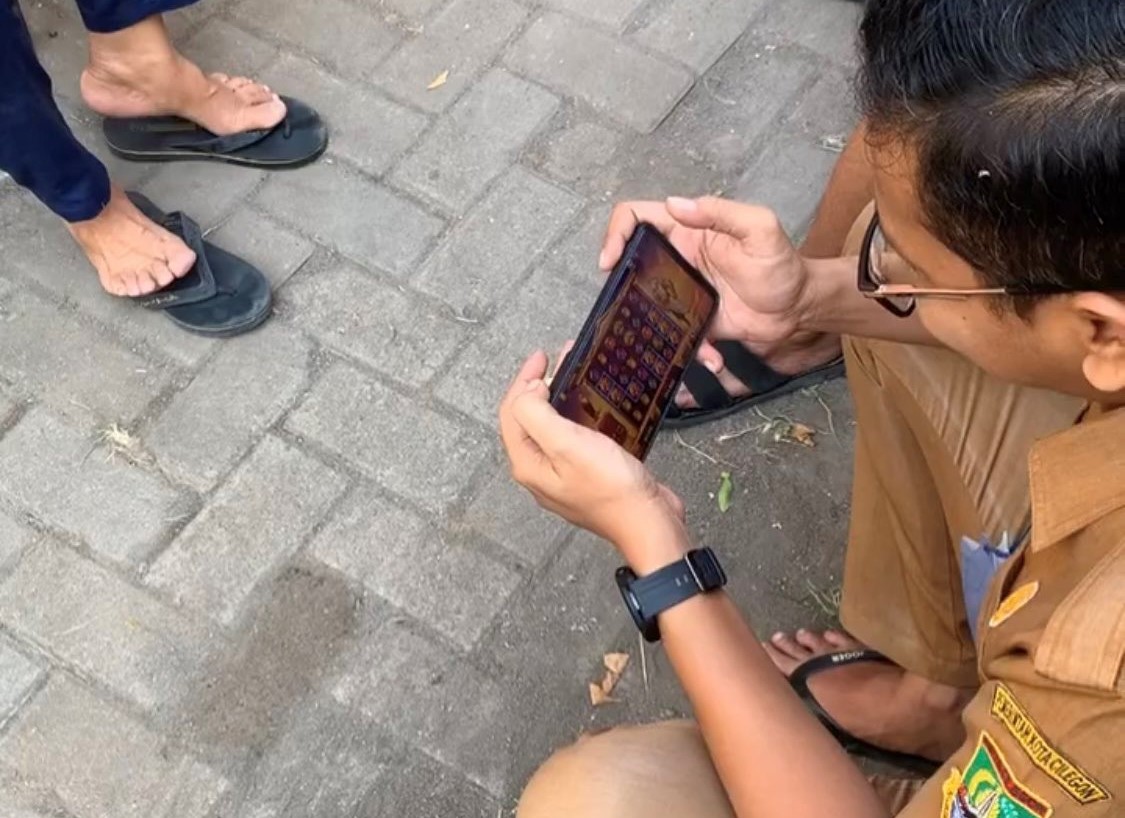 Viral di media sosial seorang pria berseragam ASN Pemerintah Kota Cilegon diduga memainkan judi slot di gawainya. - Image