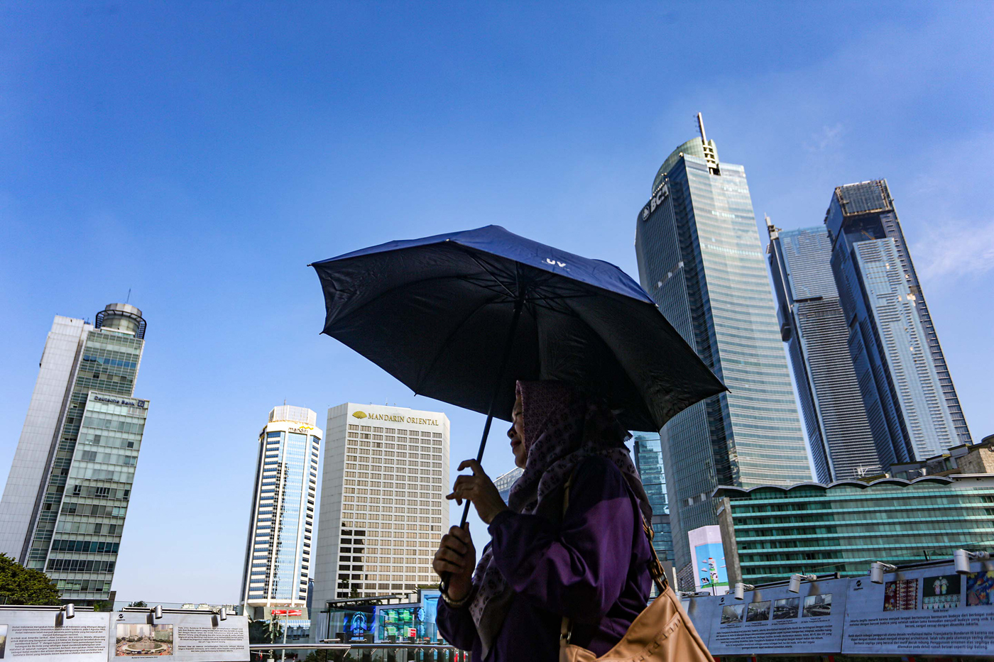 Warga beraktifitas dianjungan Transjakarta saat cuaca terik di kawasan Bundaran HI, Jakarta, Selasa (1/8/2023). - Image