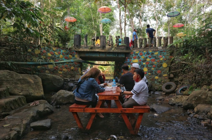 Suasana makan di tengah sungai jernih Wisata Sumber Biru Jombang. (fajar mujianto/jawapos.com) - Image