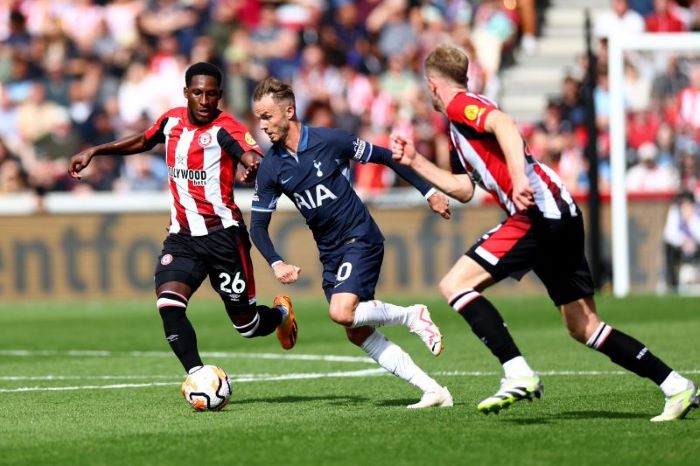 Gelandang Tottenham Hotspur James Maddison (tengah) menggiring bola melewati pemain Brentford Shandon Baptiste dalam pertandingan Liga Premier Inggris di Gtech Community Stadium pada 13 Agustus 2023. - Image