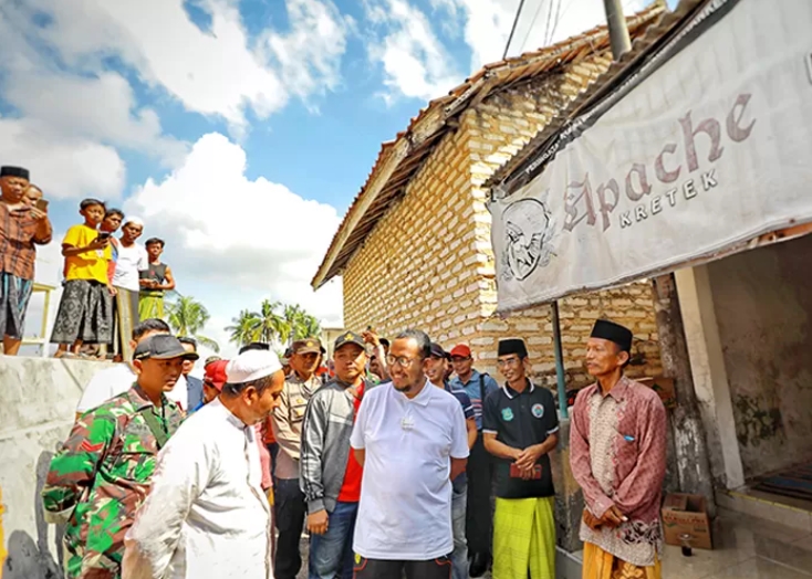 Cak Fauzi pantau langsung sumber dentuman misterius di Dusun Tengah, Desa Moncek Tengah, Kecamatan Lenteng. (Radar Madura) - Image