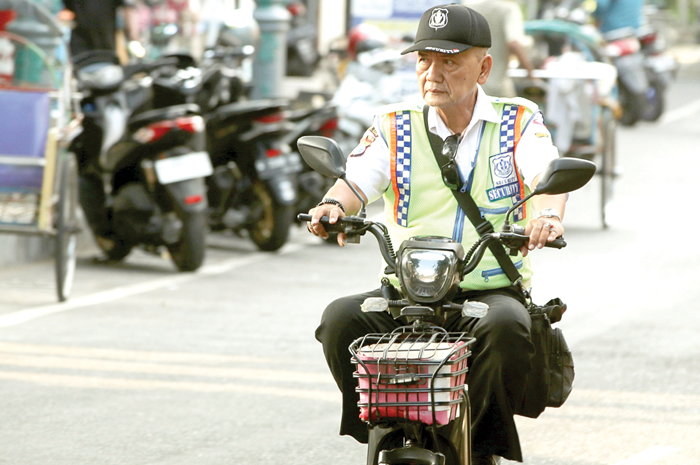MEMBAHAYAKAN: Pengendara motor listrik tidak menggunakan helm ketika melintas di Jalan Pahlawan. Penggunaan kendaraan tersebut kini menjadi atensi khusus Satlantas Polres Gresik. - Image