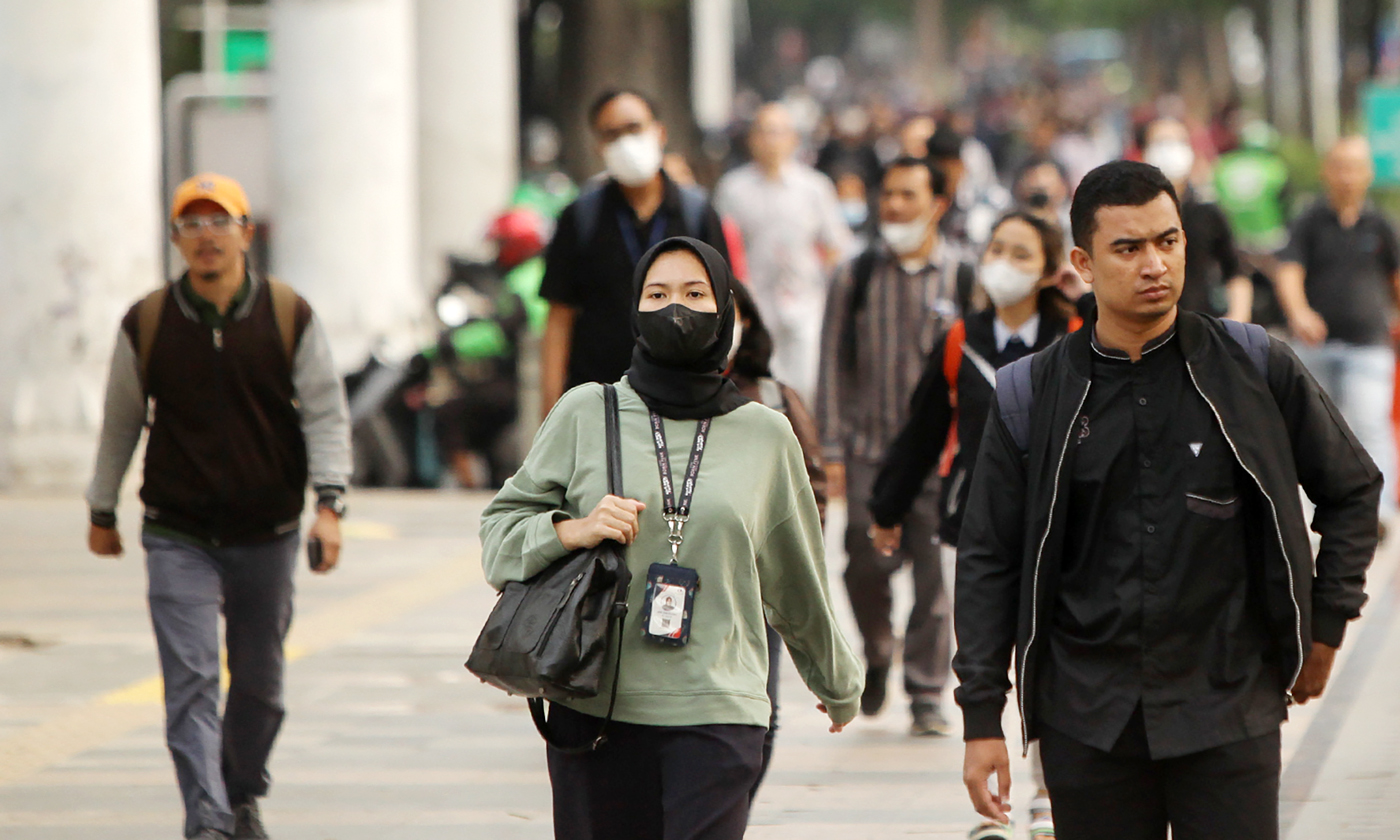 Lalu-lalang pekerja berjalan mengunakan masker untuk menghindari polusi udara sepulang di kawasan Jalan Sudirman-Thamrin, Jakarta, Jumat (25/8/2023). - Image