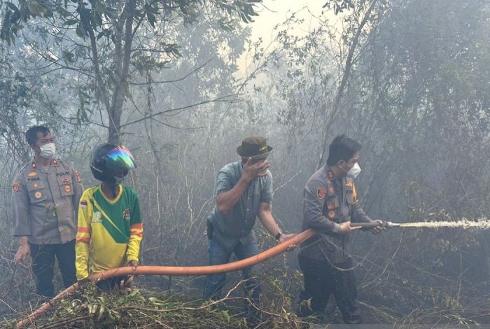 Kapolres Banjarbaru AKBP Dody Harza Kusumah terjun langsung melakukan pemadaman lahan terbakar. - Image