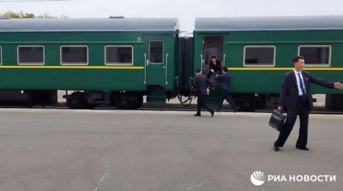 Momen ketika tim media dari Kim Jong Un berusaha melompat ke dalam kereta yang sudah berjalan. - Image