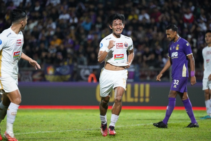 Firza Andhika (tengah) usai mencetak gol ke gawang Persik Kediri. Dia mempersembahkan golnya kepada Jakmania dan Aji Kusuma. - Image