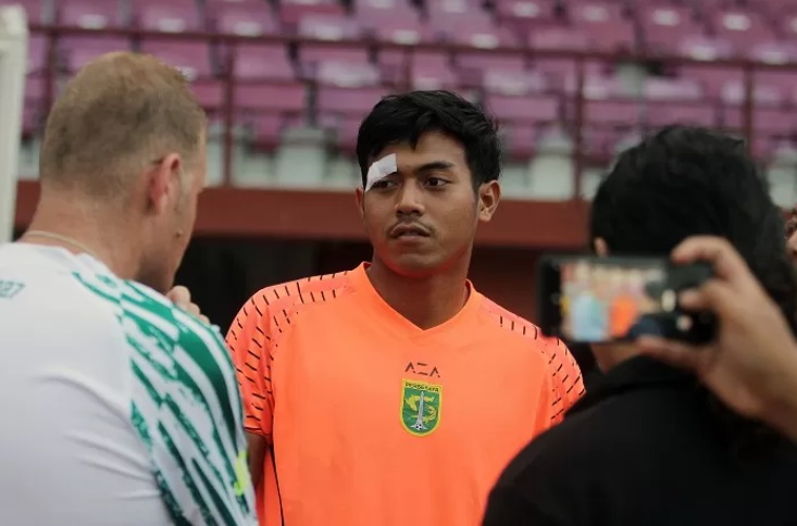 Kiper Persebaya Andhika Ramadhani dengan perban di atas mata kanannya berbincang dengan pelatih Josep Gombau saat mengikuti latihan pada Senin (18/9). - Image