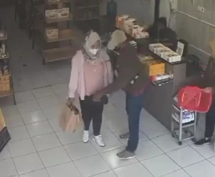 Pelaku pria yang mengambil tas korban Nurhaniyah memasukkan tas korban ke tas belanjaan si perempuan (diduga istri). (IST) - Image