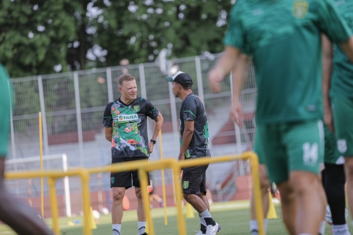 Josep Gombau (kiri) sedang berdiskusi dengan asistennya, Uston Nawawi, dalam persiapan Persebaya Surabaya menyambut Arema FC di Stadion Gelora Bung Tomo, Sabtu (23/9). - Image