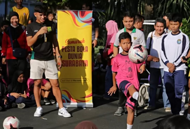 Anak-anak SD mendapat ilmu bermain bola dari pemain Persebaya Surabaya dalam road show Piala Dunia U-17 di sela CFD di Taman Bungkul, Minggu pagi (24/9). - Image
