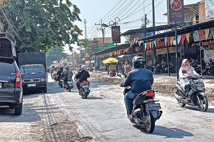 MASIH RUSAK: Kondisi Jalan Cerme arah Benjeng yang tidak rata serta aspal yang mengelupas membahayakan pengguna jalan, khususnya roda dua. Tak terlihat petugas mengerjakan jalan tersebut. - Image