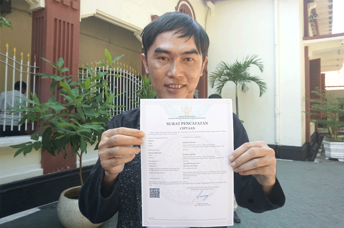 BERJUANG: Rahman Efendi menunjukkan surat pencatatan ciptaan lagu Nasib Force One Buruk di PN Surabaya. - Image
