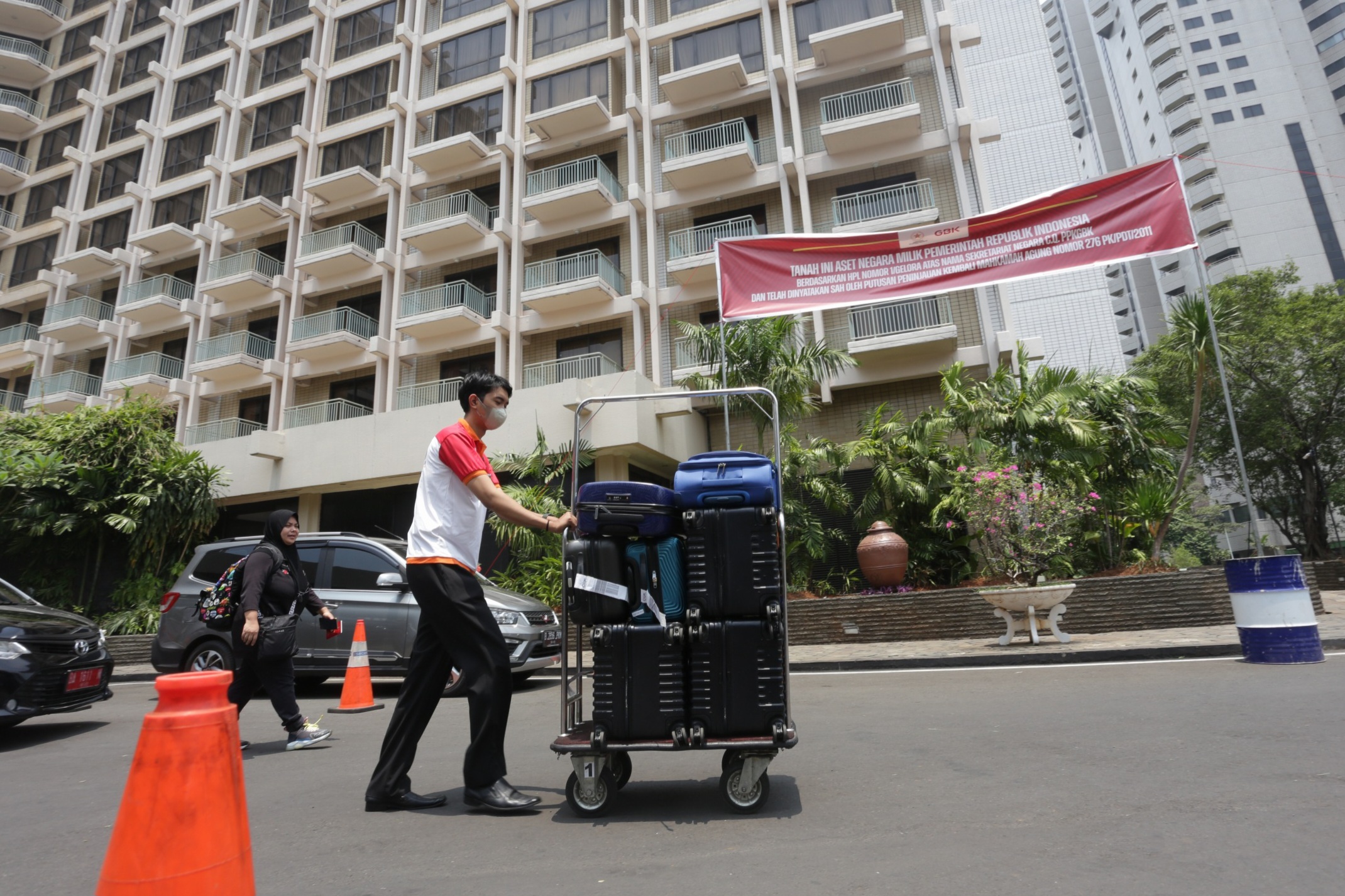 Petugas memasang spanduk pemberitahuan di depan Hotel Sultan, Kompleks GBK, Jakarta, Rabu (4/10). - Image