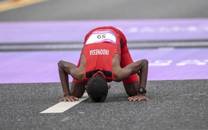 Pelari Indonesia Agus Prayogo bersujud saat tiba di garis finis pada final marathon putra Asian Games 2022 di Qiantang River Green Belt, Hangzhou, Kamis (5/10/2023). ANTARA/Hafidz Mubarak A - Image