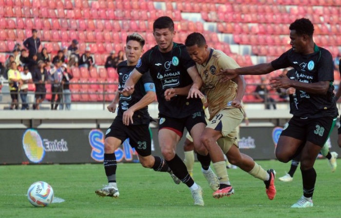 Pemain Arema FC Dendi Santoso (kedua kanan) berebut bola dengan pemain PSS Sleman, Kevin Gomes (kedua kiri) dan Nyoman Ansanay (kanan) dalam lanjutan Liga 1 di Stadion Kapten I Wayan Dipta. - Image
