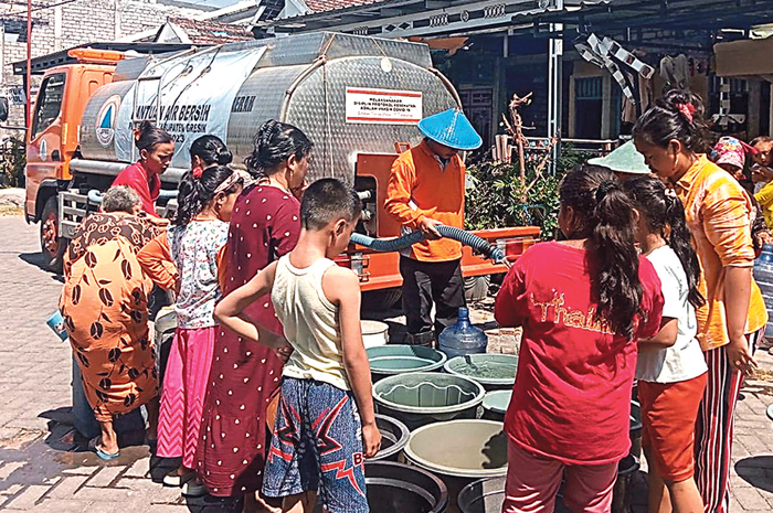 KEMARAU PANJANG: Petugas BPBD Gresik saat mendistribusikan air bersih ke desa-desa terdampak kekeringan. - Image