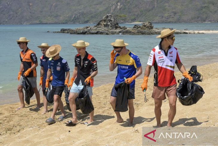Pembalap MotoGP dari tim LCR Honda Idemitsu-Castrol (Honda) Takaaki Nakagami (kanan) bersama pembalap tim Aprilia Racing Maverick Vinales (ketiga kanan) membersihkan pantai. - Image