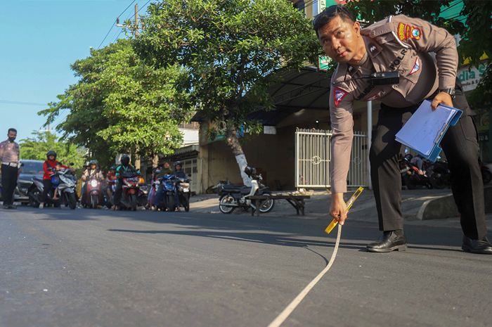 HUMAN ERROR: Petugas dari Unit Laka Lantas Polrestabes dan Polsek Tambaksari melakukan olah TKP kecelakaan yang menewaskan satu orang. - Image
