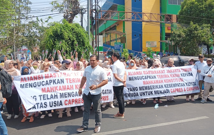 Aliansi Masyarakat Jakarta Timur (AMJT) menggelar aksi turun ke jalan untuk membagi-bagikan bunga mawar kepada masyarakat dan pengguna jalan yang ada di kawasan Pasar Pramuka Jaktim. - Image