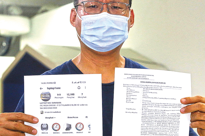 MERUGI: Murdani Hadiwijaya, pemilik Toko Laptop One, menunjukkan surat laporan polisi dan tangkapan layar akun IG milik tokonya yang diretas Rabu (18/10). - Image