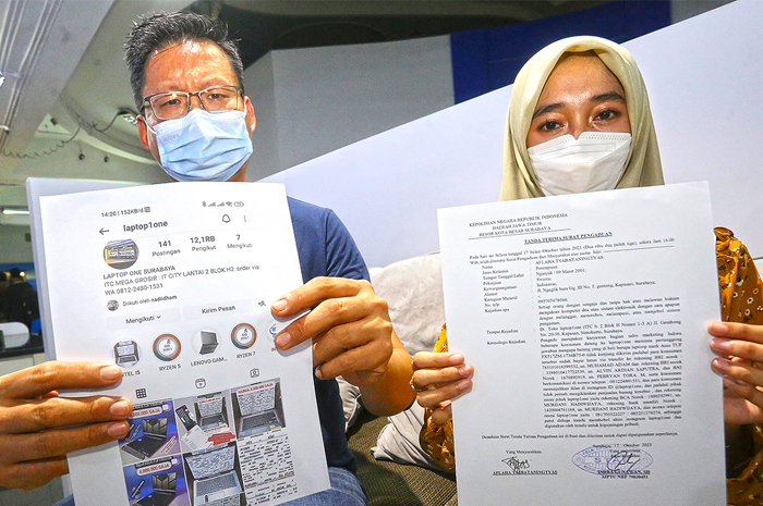 MERUGI: Korban Murdeni Hadiwijaya (kiri) dan karyawannya, Afiaha Tsabataningtyas, menunjukkan surat laporan polisi dan tangkapan layar akun instagram milik tokonya yang diretas. - Image