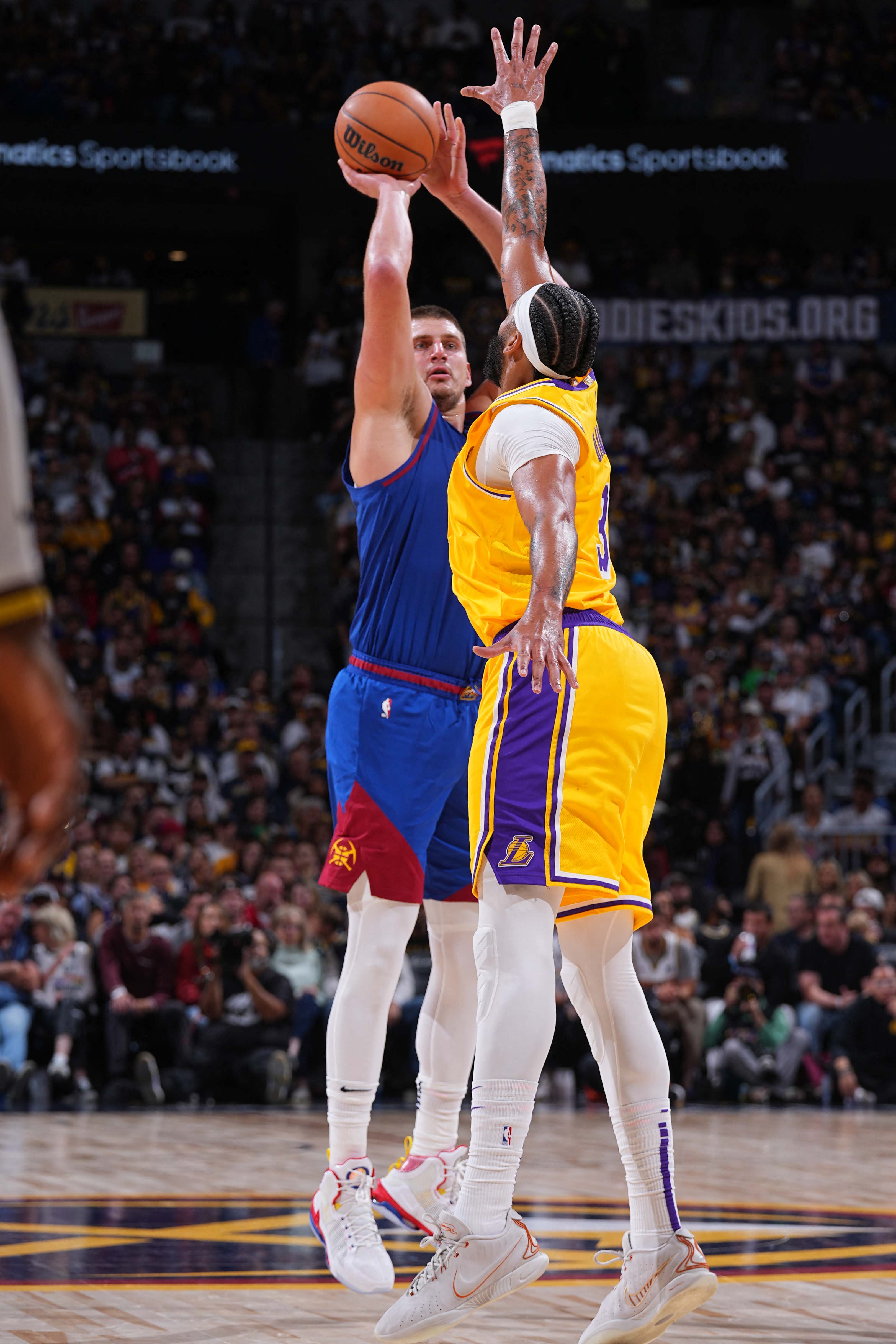 Nikola Jokic (kiri) dihadang saat hendak melepaska tembakan kemarin. - Image