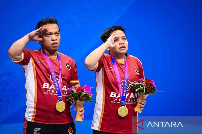 Peraih medali emas ganda campuran Indonesia Rina Marlina - Subhan memberi hormat saat upacara penyerahan medali bulu tangkis nomor ganda campuran SH6 Asian Para Games 2022 di Hangzhou. (ANTARA) - Image