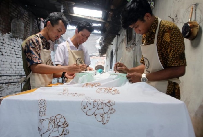 Proses mewarnai batik yang akan dijadikan suvenir Piala Dunia U-17. (Radar Surabaya) - Image