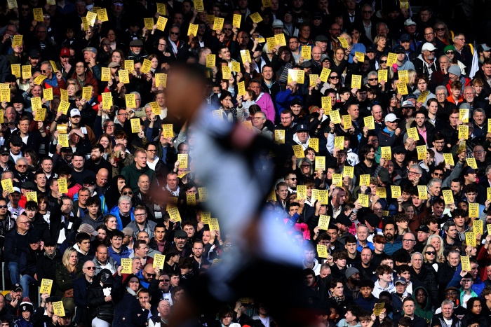Fans Fulham mengangkat kartu kuning pada menit ke-18 saat melawan Man United sebagai bentuk protes kenaikan harga tiket. (Sportbible) - Image