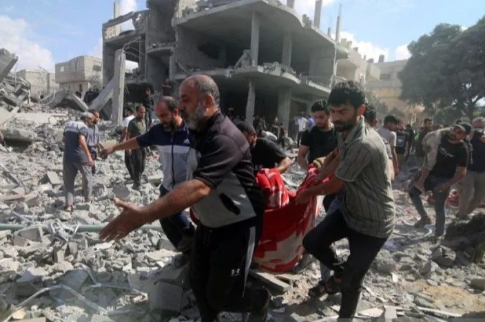 Sejumlah warga mengangkut para korban dari sebuah gedung yang hancur akibat serangan Israel di Kota Rafah di Jalur Gaza bagian selatan, Selasa (17/10). Sumber: Khaled Omar/tm/am./Xinhua/ANTARA - Image